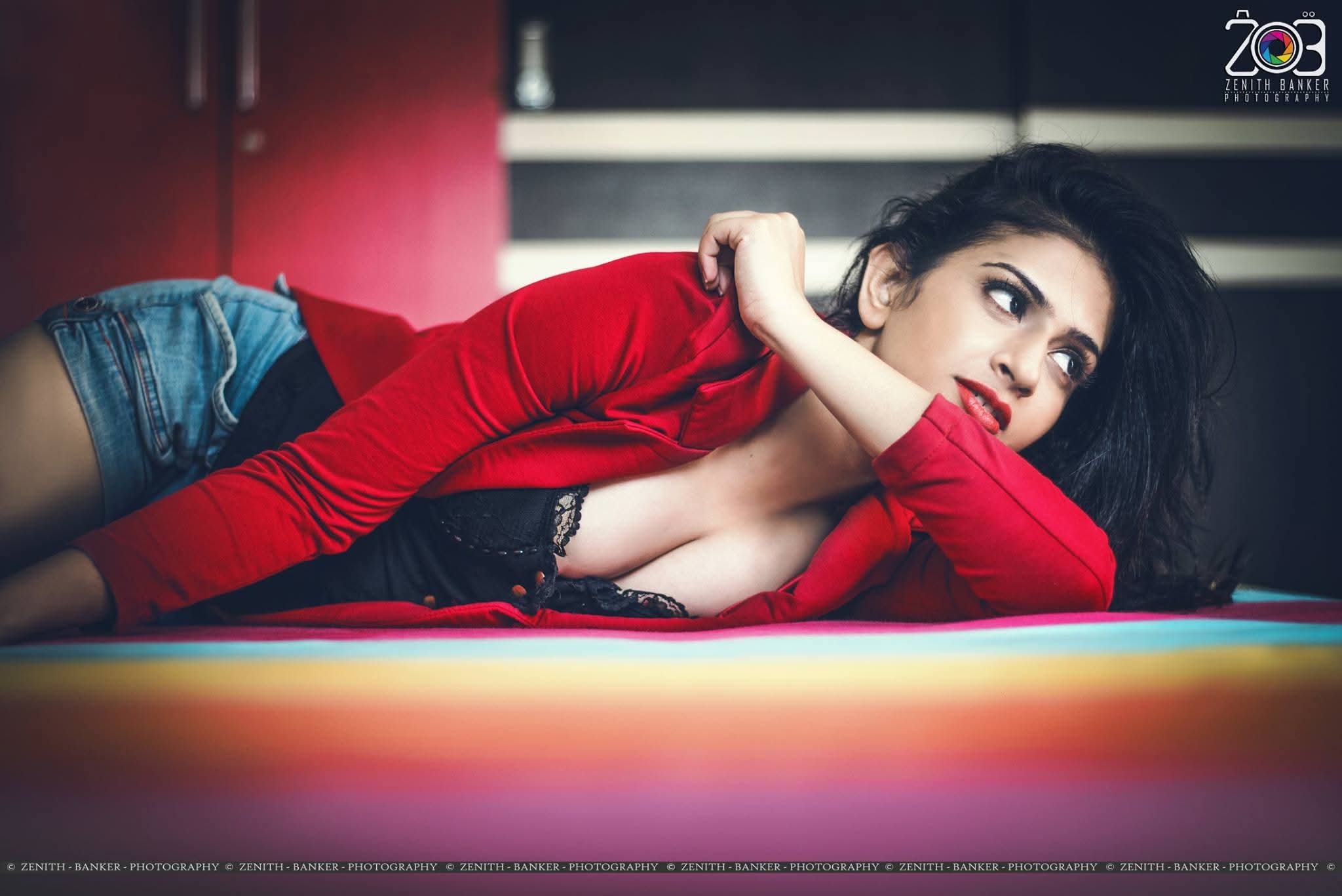 Maulika Patel leaning against a tree/rock in a rustic outdoor setting.