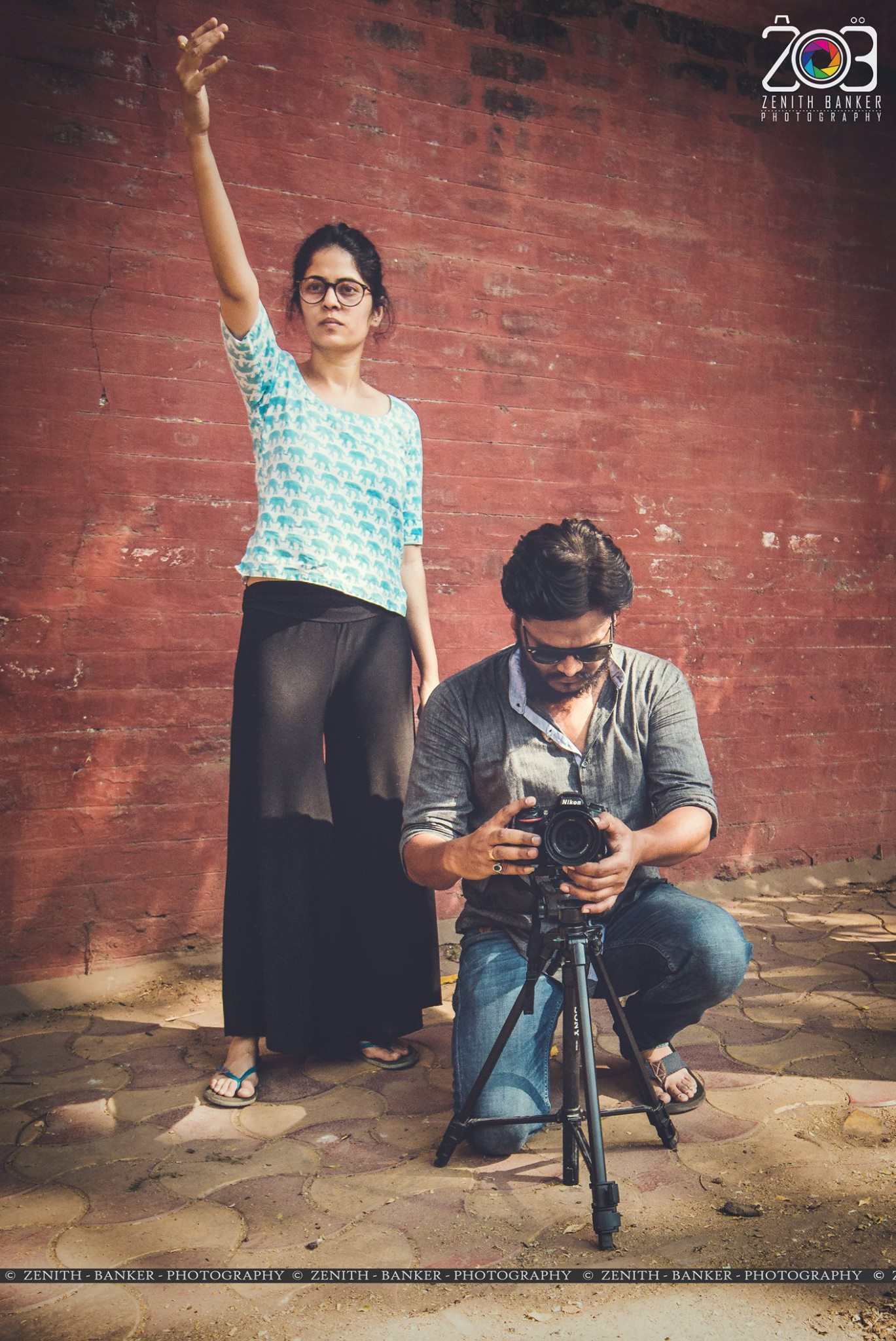 Zenith Banker and a team member adjusting professional camera gear and lighting settings.